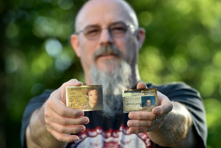 Al Dyer shows his 1980s driver's license and Bath Iron Works identification card Thursday at his home in Fairfield.