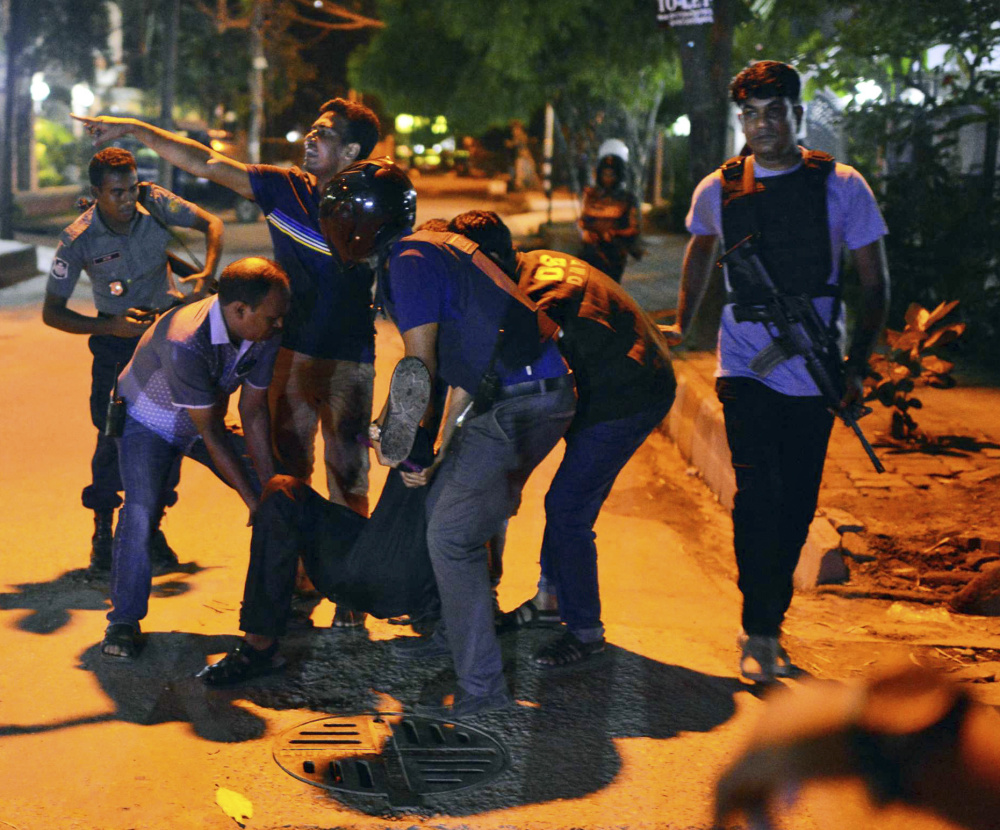 A wounded person is tended to after gunmen attacked a restaurant popular with foreigners in a diplomatic zone of the Bangladeshi capital of Dhaka on Friday.