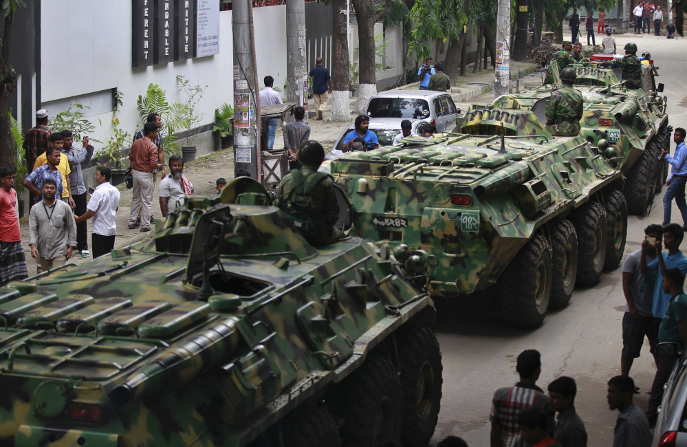 Armored vehicles pass by after an operation against militants who took hostages at a restaurant popular with foreigners in Dhaka, Bangladesh, Friday night, leaving at least 28 dead after a dramatic 10-hour siege.