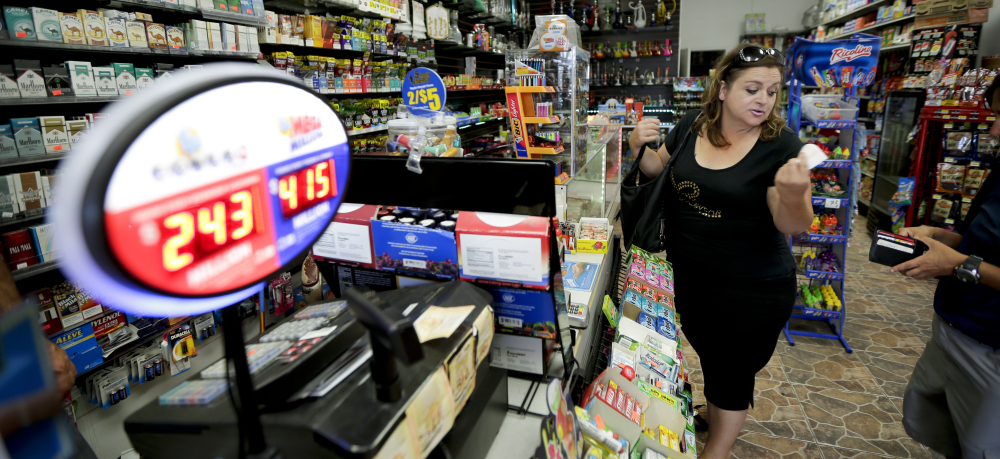Diana Moore buys a Mega Millions lottery ticket Friday in San Diego. The odds for picking the correct numbers on five white balls and one yellow ball in the Mega Millions are one in 259 million. Tuesday's jackpot will be the largest since a $430 million Powerball win in May.