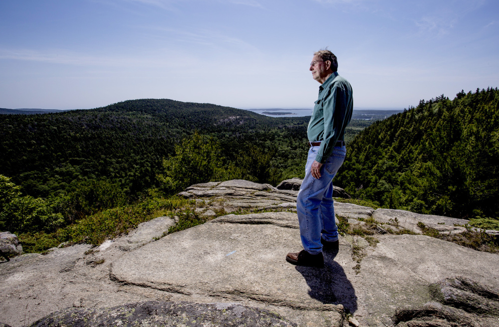 Jack Russell, a board member of Friends of Acadia and a lifelong resident of Mount Desert, poses atop Beach Cliff last week. The park inhabits many of his earliest memories, and this is where he and his wife have retired.
