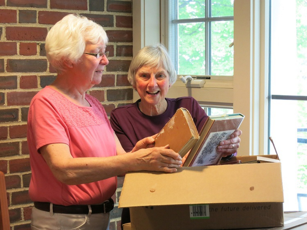 Rosalie Ketchum, left, and Ann Siekman look over books donated for the Friends of Norway Memorial Library's used book sale Thursday through Saturday.