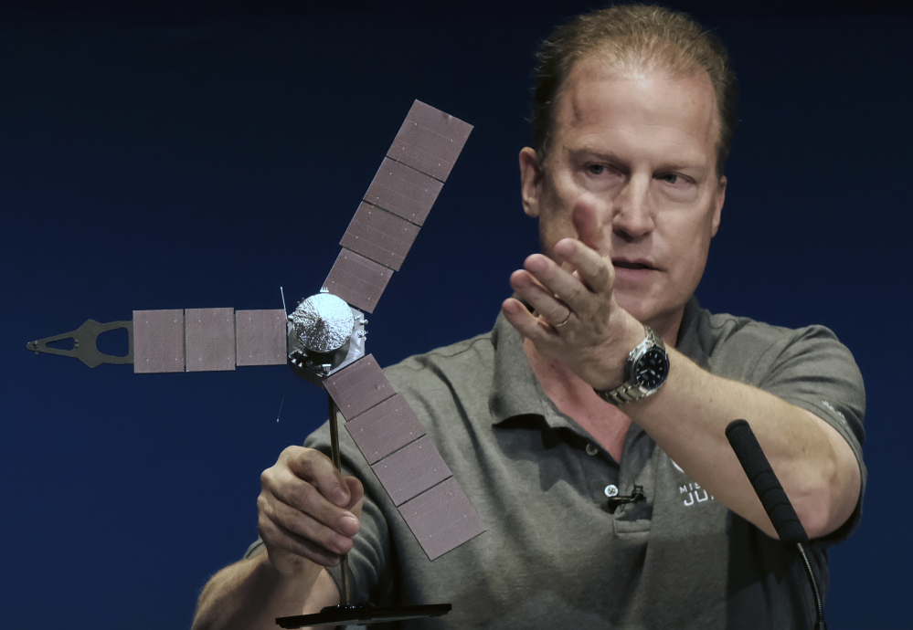 Rick Nybakken, Juno project manager, holds a model of the Juno spacecraft at a briefing at the Jet Propulsion Laboratory in Pasadena, Calif., on Monday while talking about the solar panels and the orbit it will take around Jupiter. The solar-powered spacecraft was on its way toward Jupiter for the closest encounter with the biggest planet in our solar system.