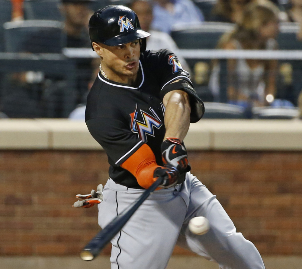 Giancarlo Stanton of the Miami Marlins hits a two-run homer Tuesday night in the seventh inning of the 5-2 victory against the New York Mets.