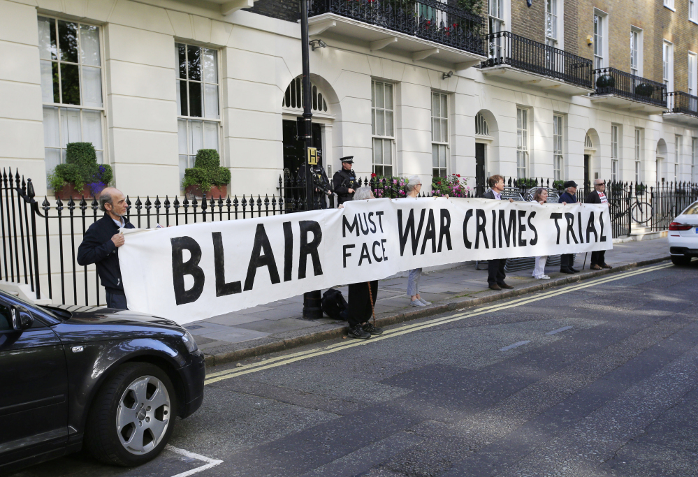 Protesters hold a banner outside the home of former Prime Minister Tony Blair ahead of the publication of the report into the Iraq War in London on Wednesday.