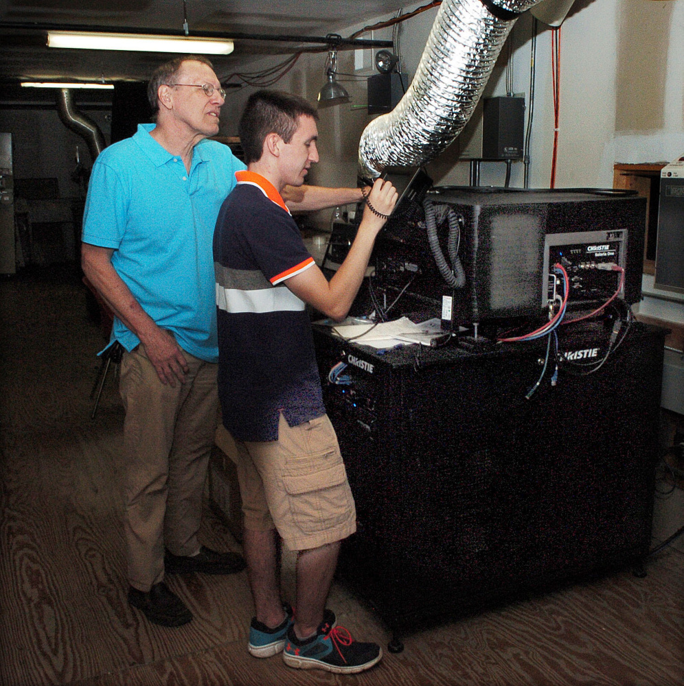 Railroad Square Cinema co-owner Alan Sanborn, left, watches on Wednesday as Logan Rollins sets up a digital projector for the Maine International Film Festival, which begins Friday night.