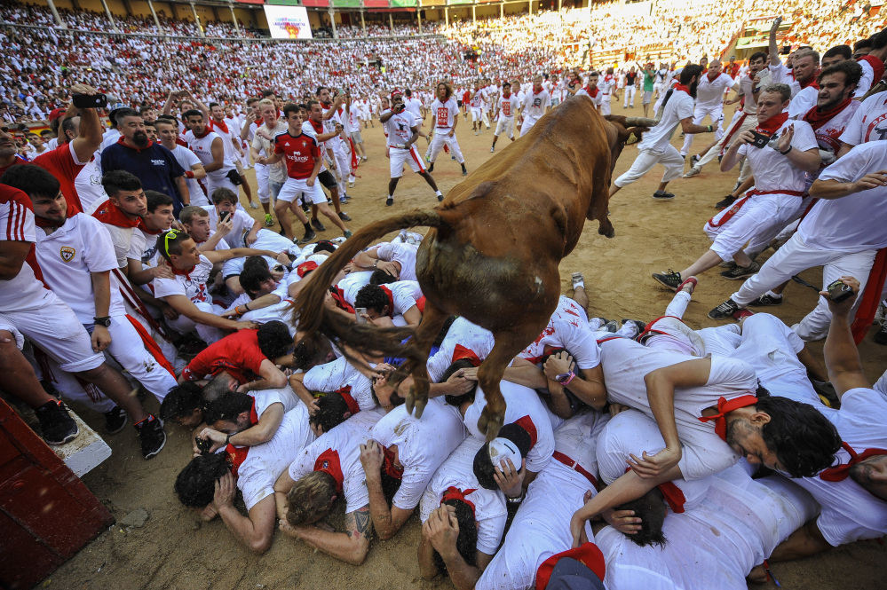 A cow jumps over revelers during the cows' festival at the end of the second running of the bulls at the San Fermin Festival in Pamplona, northern Spain, on Friday.