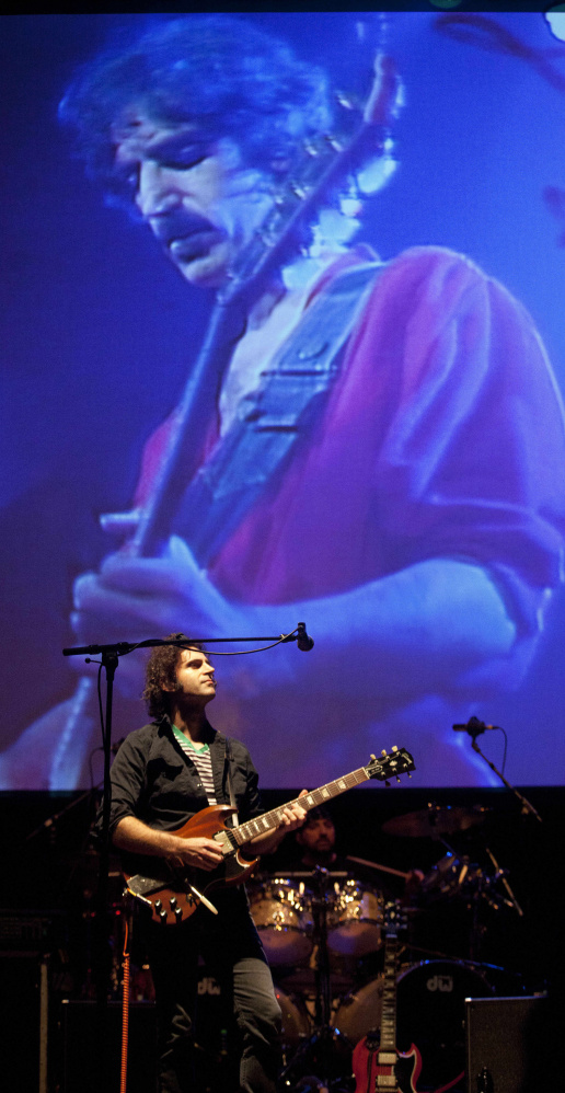 Dweezil Zappa performs in front of a projection of his late father, Frank, in Bristol, England, in 2011.