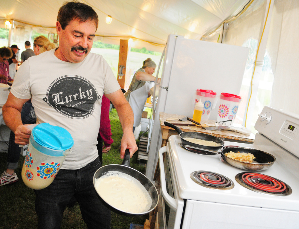 Larry Fleury swirls batter around in a pan Friday as he makes crepes during the opening night of Le Festival de La Bastille in Augusta.
