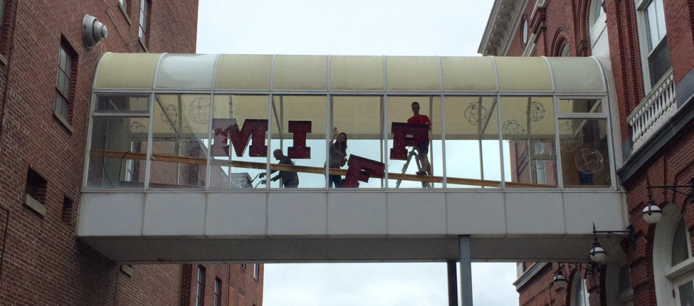 People hang letters spelling the acronym for the Maine International Film Festival – MIFF – in a skywalk In Waterville on Friday. The opening night attendance didn't break records.