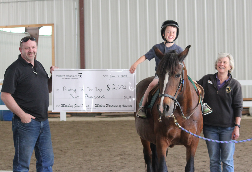 Modern Woodmen of America's Tim Graham recently presented Riding to the Top Therapeutic Riding Center with a matching gift of $2,000 during the center's second annual Dances With Horses fundraising event.