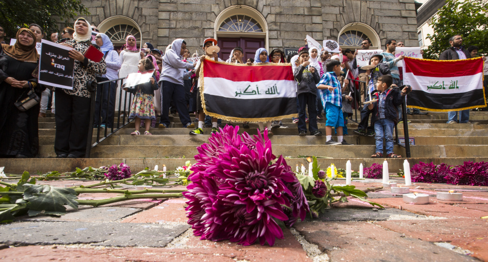 Flowers are placed at the steps of the First Parish Church in Portland on Sunday during a vigil to honor the victims of the July 3 terrorist attack in Baghdad.
Ben McCanna/Staff Photographer