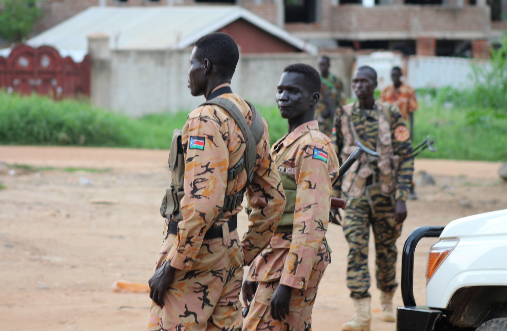 South Sudanese policemen and soldiers stand guard along a street following renewed fighting in South Sudan's capital of Juba on Sunday. Widespread casualties were reported in the city.