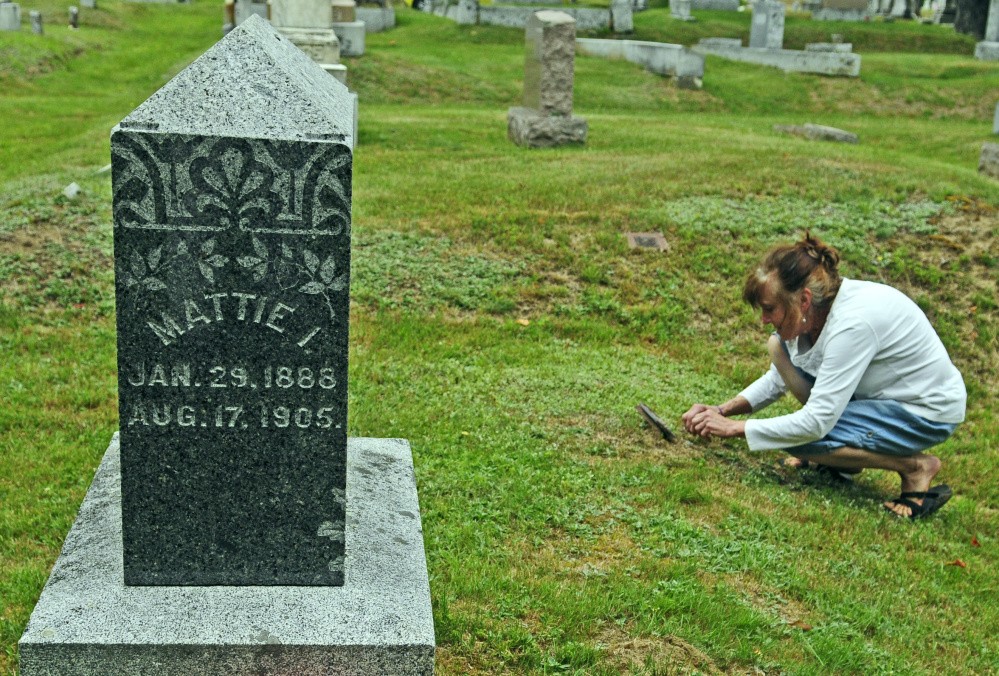 Ellen Bowman of Readfield, who recently wrote a tribute to Mattie Hackett, a 17-year-old girl killed in 1905, looks at another Hackett family grave marker Thursday at Readfield Corner Cemetery.