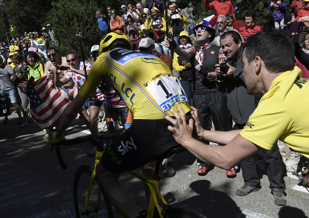 Britain's Chris Froome, is helped after he crashed during the twelfth stage of the Tour de France. His bike ruined, Froome had to temporarily switch to a yellow race assistance bike.