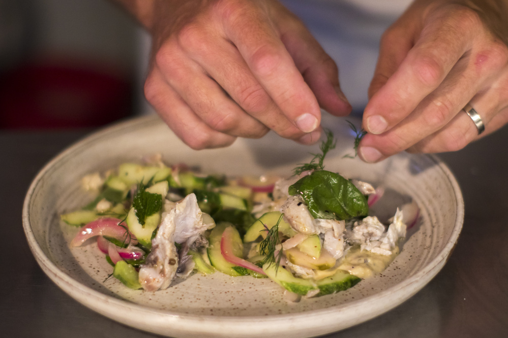 Drifters Wife chef Ben Jackson garnishes the marinated bluefish with dill sprigs.
