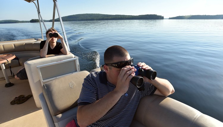 Richard LaBelle, right, and Steven Schoeneck observe a loon Saturday on Great Pond in Rome. Last year's Maine Audubon count showed numbers had doubled since the first count in 1984.