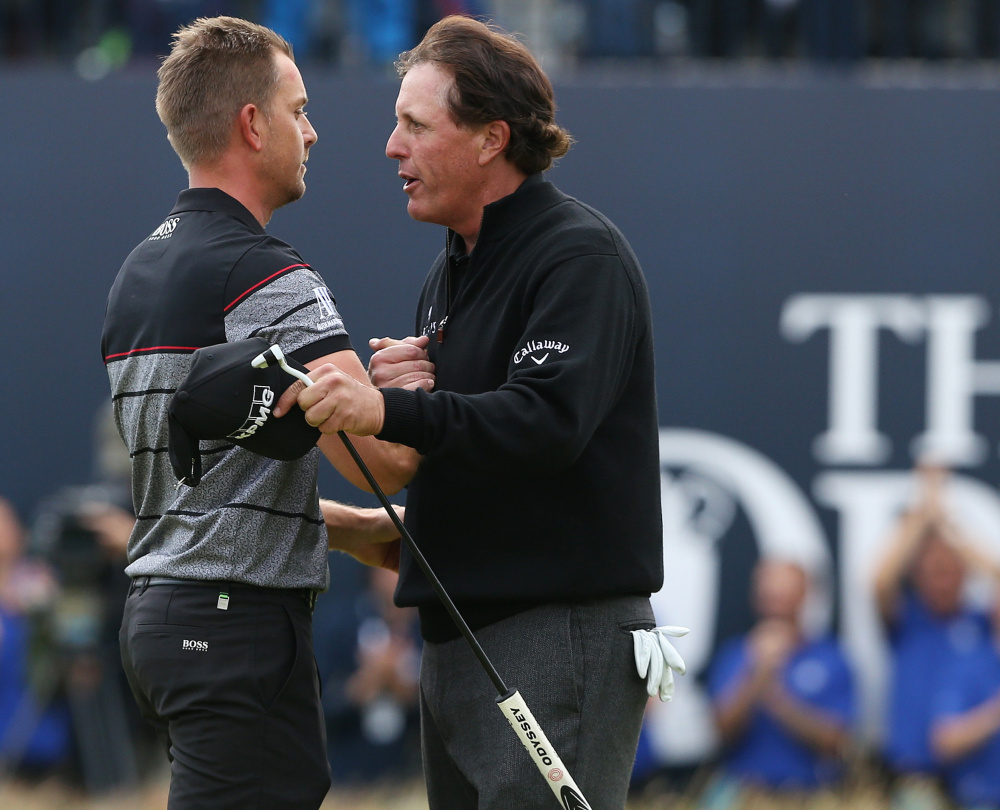 Henrik Stenson, left, is congratulated by Phil Mickelson after winning the British Open on Sunday at Troon, Scotland. Stenson closed with a 63 to hold off Mickelson, who shot a 65.