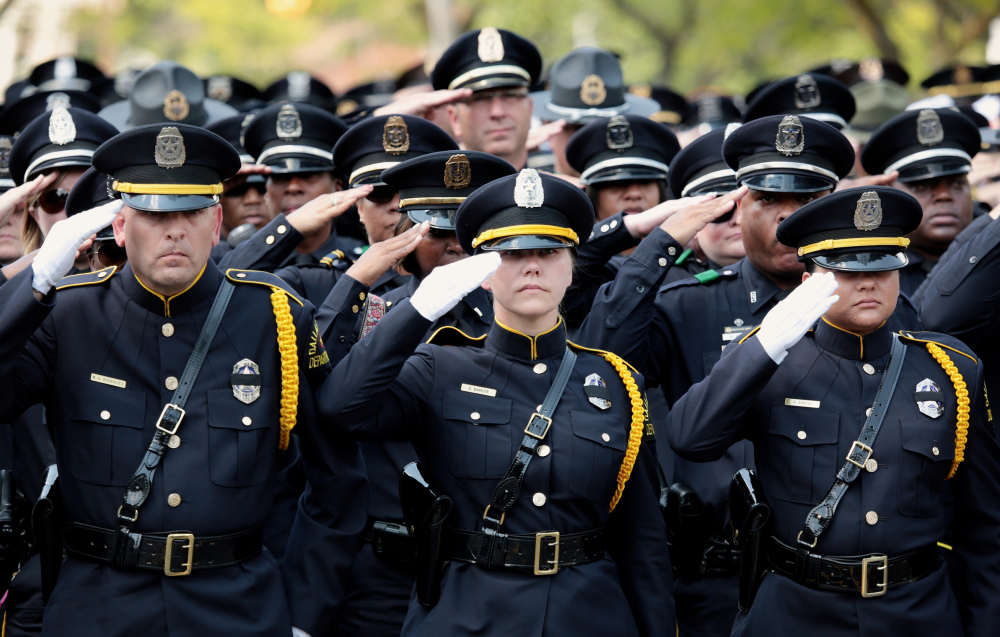 Dallas police officers salute fallen fellow officer Michael Krol on Tuesday.