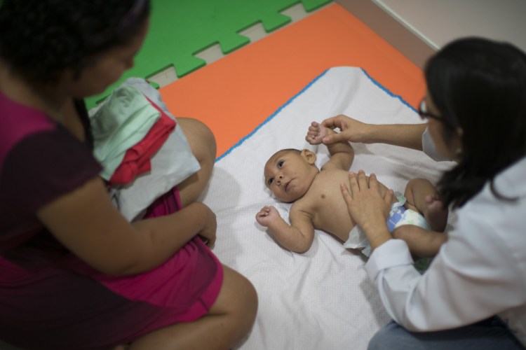 Jaqueline Vieira, left, watches as her 3-month-old son Daniel, who was born with microcephaly, undergoes physical therapy in Recife, Brazil, in January. An increase in the number of newborns with microcephaly in Brazil has been linked to the emergence there last year of the Zika virus.