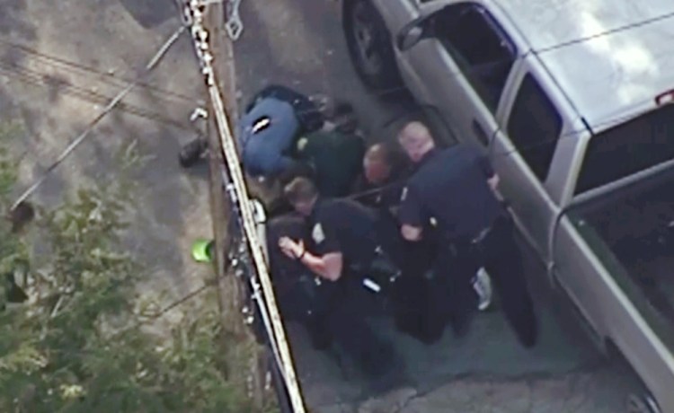 This image made from a helicopter video shows officers pummeling Richard Simone, who had kneeled on the ground after a high-speed chase May 11 in Nashua, N.H.
