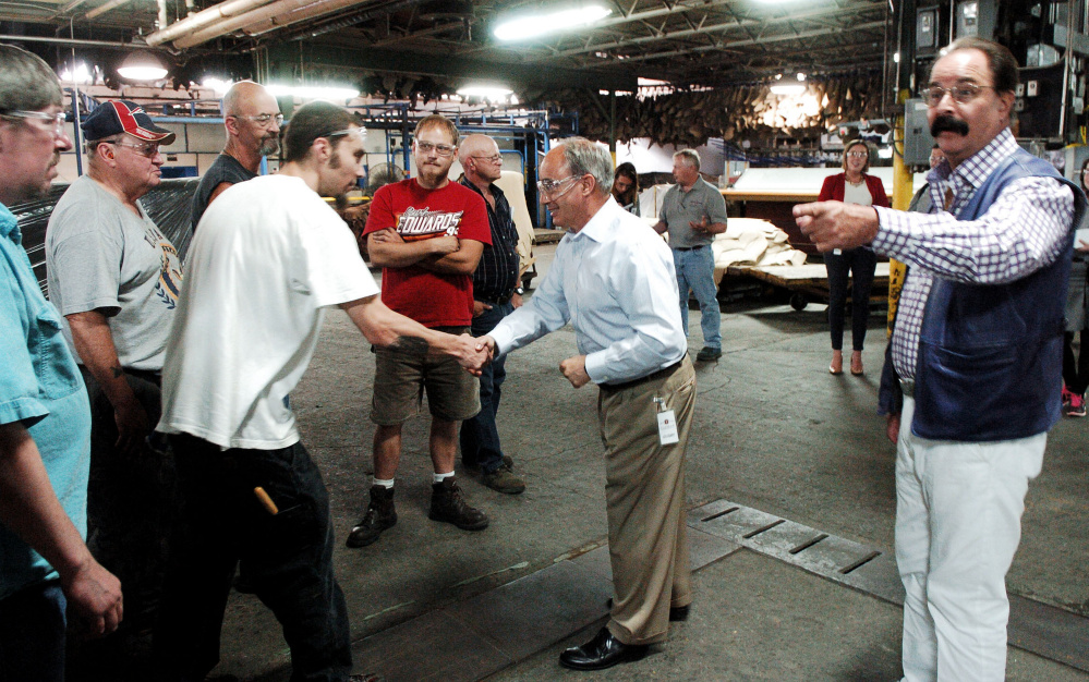 Republican Rep. Bruce Poliquin meets employees of Tasman Leather Group on Wednesday during a tour of the mill in Hartland mill. At right is Norman Tasman, company president and CEO. Poliquin would not comment during his appearance on the Republican Party's nomination of Donald Trump.