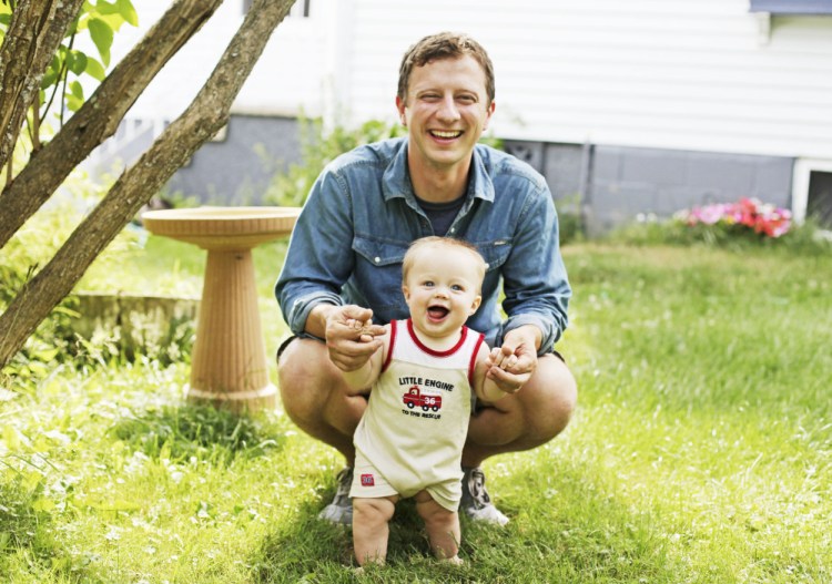 Tristan Noyes, newly appointed executive director for the Maine Grain Alliance, with his son, Bentley, 7 months, in their South Portland yard.
