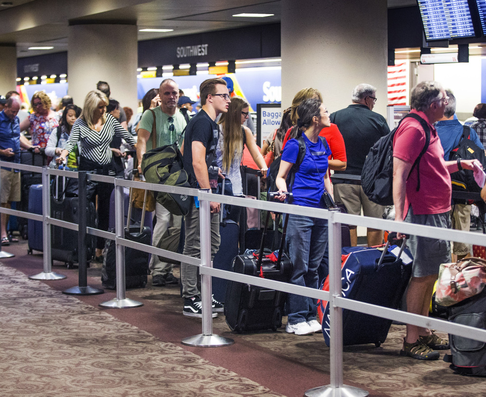 Passengers wait in the Southwest Airlines check-in line at Sky Harbor International Airport in Phoenix on Thursday, after one of the largest disruptions in the airline's history.