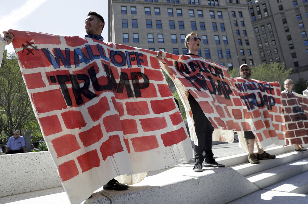 Immigrant rights activists hold up a fabric wall to protest against Republican presidential candidate Donald Trump on Wednesday in Cleveland, during the third day of the Republican convention.