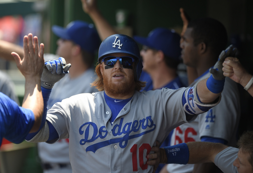 Justin Turner of the Los Angeles Dodgers gets a dugout welcome after his three-run homer in the third inning of a 6-3 win over the Nationals and pitcher Stephen Strasburg at Washington on Thursday. Turner also had a home run in the first inning.