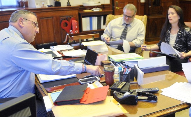 Gov. LePage works on his third State of the State address in 2014, with staffers including press secretary Adrienne Bennett and communications director Peter Steele. LePage has asked his employees to communicate with handwritten notes that are never archived.