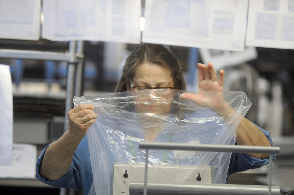 Tricia York packages a product after testing it at Alternative Manufacturing Inc. in Winthrop Wednesday.(Photo by Andy Molloy/Staff  Photographer)