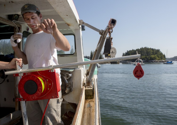 Bryan Kelley uses an automatic jigging machine he's testing as part of a project with The Nature Conservancy. 