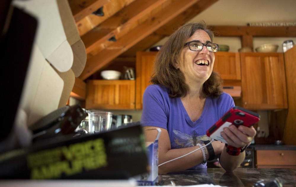 Jessie Levine listens to her recorded outgoing phone message on her iPhone in Springfield, N.H. Levine's own tones were blended with a relative's voice to re-create what she sounded like before Lou Gehrig's disease robbed her of her speech.