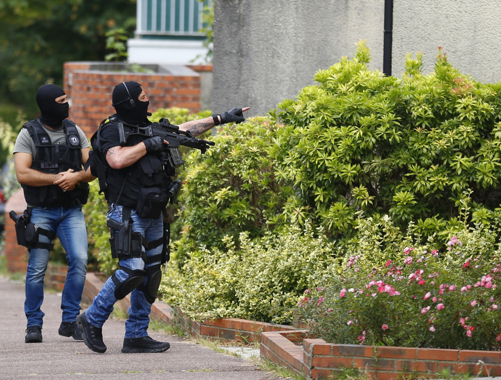 Hooded police officers conduct a search in Saint-Etienne-du-Rouvray, Normandy, France, following an attack at a church that left a priest dead Tuesday.