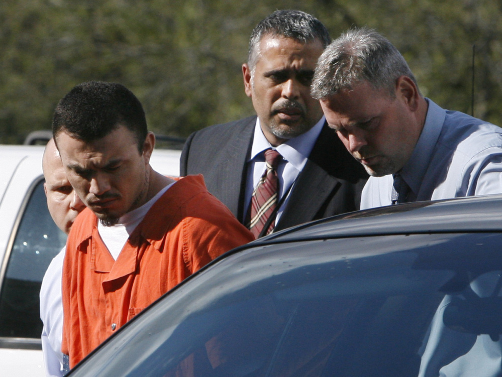 Ingmar Guandique, 27, left, who was accused of killing Chandra Levy, is escorted into the Violent Crimes Unit by detectives Emilio Martinez, and Todd Williams, right, in Washington, on Wednesday, April 22, 2009. At far left is detective Anthony Brigidini.