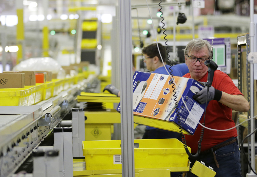 Workers process outgoing orders at Amazon.com's fulfillment center in DuPont, Wash. The company has announced plans for 17 new distribution centers in the U.S. alone since March, and has 123 centers worldwide.