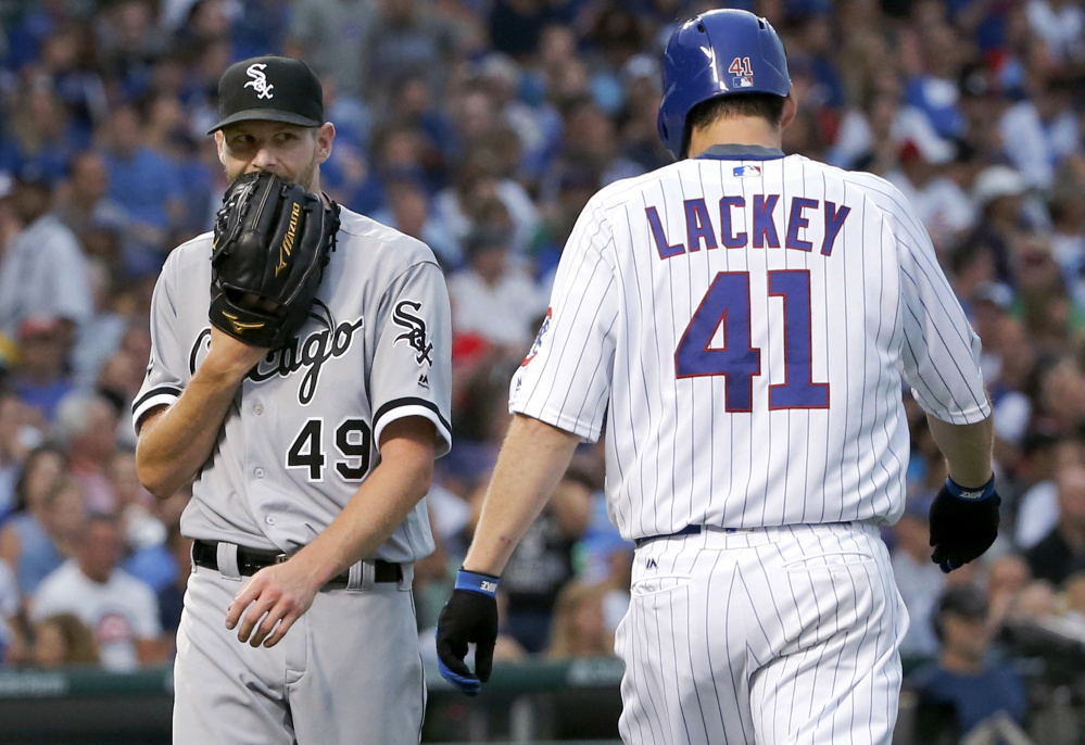 Pitcher Chris Sale, left, of the White Sox and pitcher John Lackey of the Cubs pass each other after Sale fielded a ground ball by Lackey and threw him out first to end the second inning. The Cubs won, 3-1, at Wrigley Field.