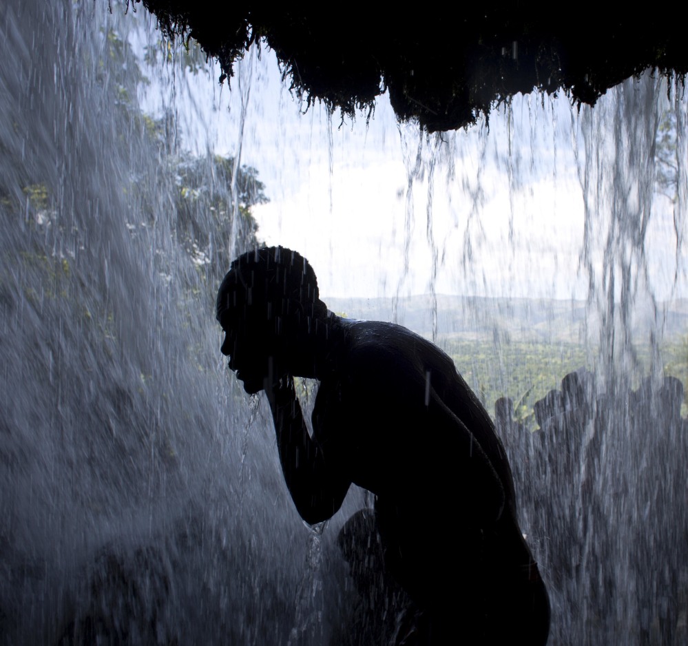 A pilgrim bathes in a waterfall believed to have purifying powers, during a Voodoo celebration July 16 in Saut d' Eau, Haiti. It is one of two major Voodoo festivals in Haiti.