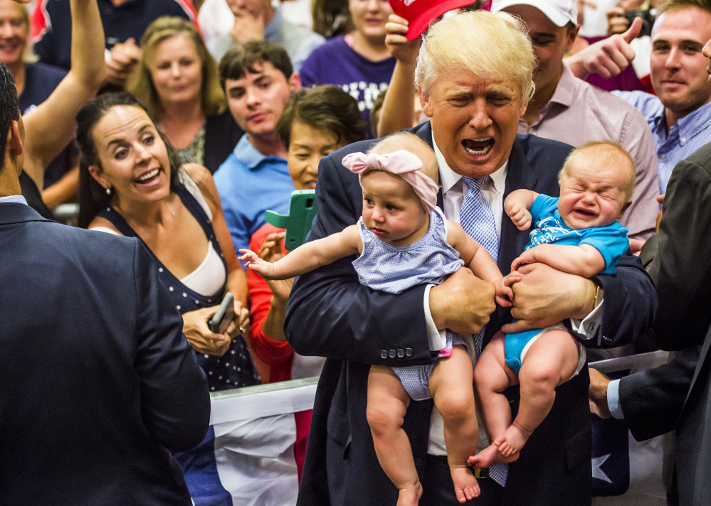 Donald Trump holds baby cousins Evelyn Kate Keane, left, and Kellen Campbell, following his speech in Colorado Springs on Friday. Trump encouraged chants of "lock her up" during the event.