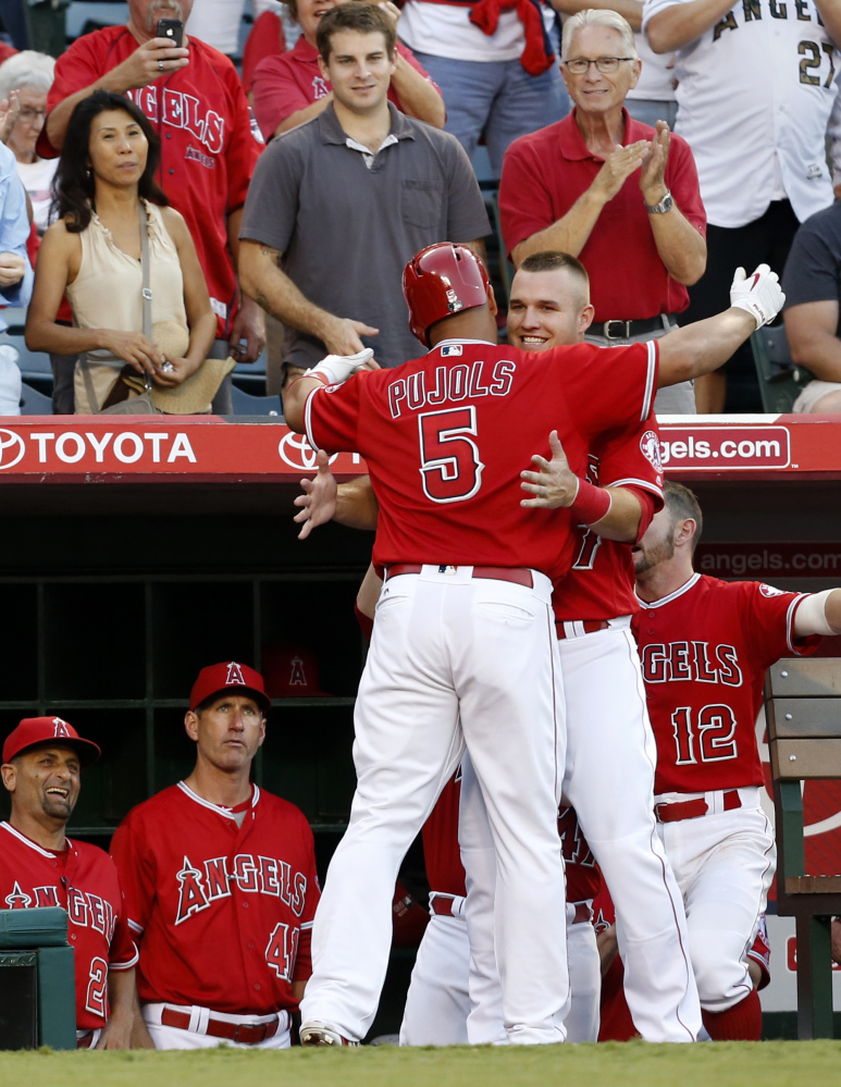 Albert Pujols of the Los Angeles Angels is congratulated by Mike Trout after hitting a two-run homer in the third inning Saturday night against Boston.