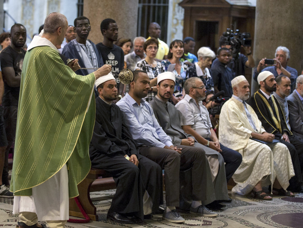 Muslims attend a Mass in Rome's Saint Mary in Trastevere church, Italy, Sunday, July 31, 2016. Imams and practicing Muslims attended Mass across Italy, from Palermo in the south to Milan in the north, in a sign of solidarity after the France church attack in which an elderly priest was slain. (via AP)