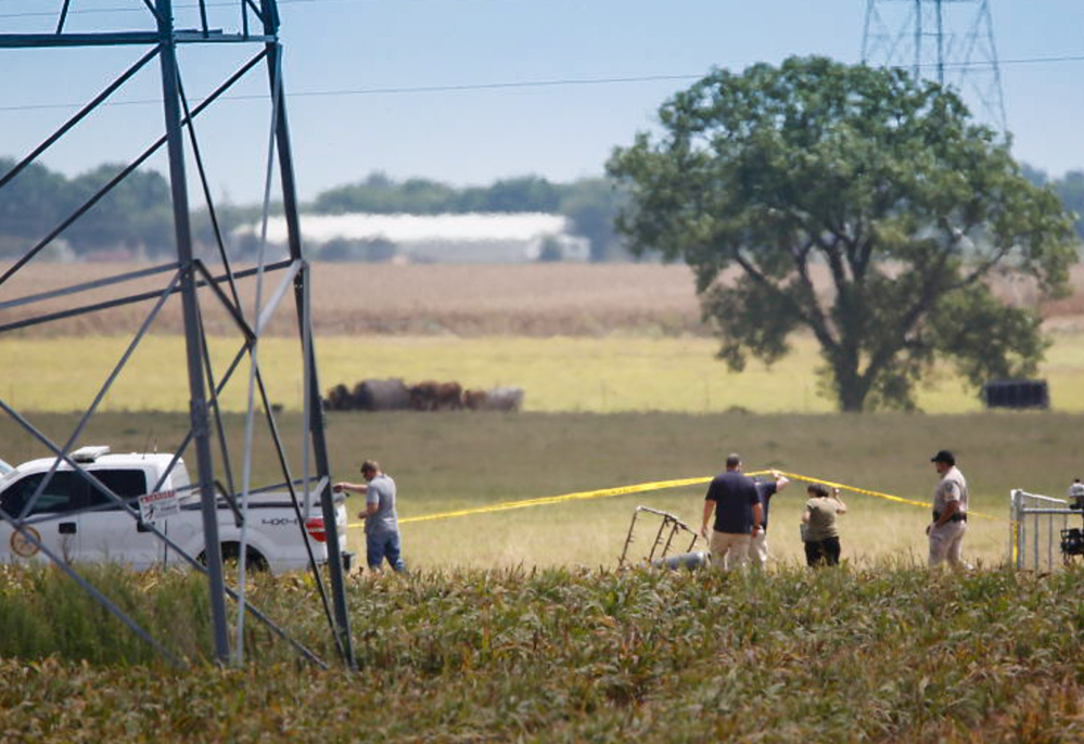 Investigators surround the scene in a field near Lockhart, Texas, where a hot air balloon carrying 16 people collided with power lines Saturday. 