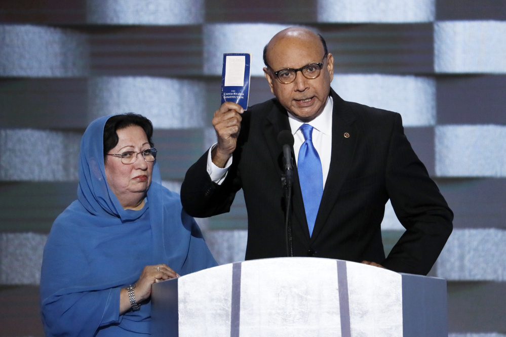 Khizr Khan, father of fallen Army Capt. Humayun S. M. Khan, holds up a copy of the Constitution of the United States as his wife listens during the final day of the Democratic National Convention in Philadelphia. <em>Associated Press/J. Scott Applewhite</em>