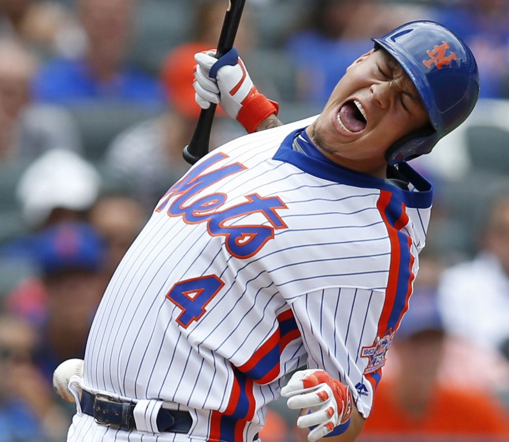 New York Mets' Wilmer Flores reacts as he is hit by a pitch during the third inning of a baseball game against the Colorado Rockies, Sunday, July 31, 2016, in New York. (AP Photo/Kathy Willens)