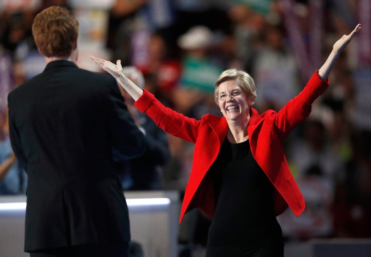 Sen. Elizabeth Warren, D-Mass. throws her arms open as she takes the stage and is greeted by Rep. Joe Kennedy, D-Mass., prior to her speech at the Democratic National Convention in Philadelphia.