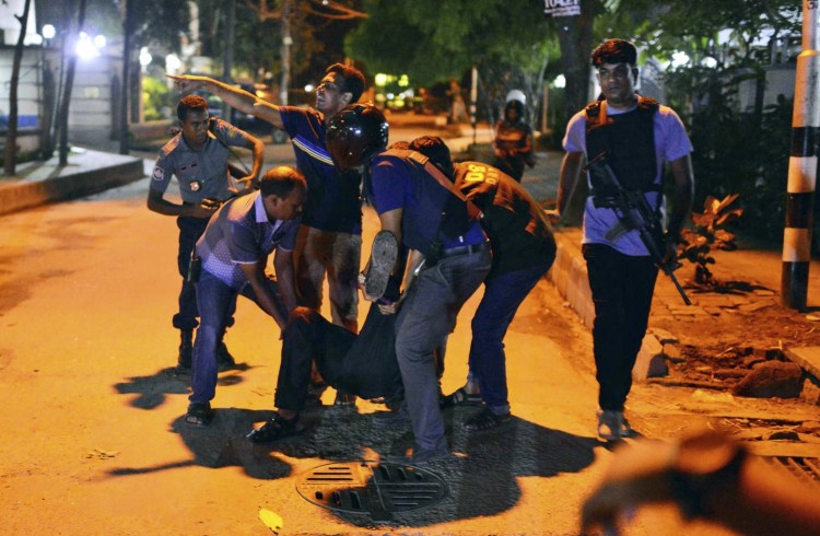 People help an injured person after gunmen attacked a restaurant in the Bangladeshi capital of Dhaka. The militants took hostages and exchanged gunfire with security forces before commandos ended the siege early Saturday.
Associated Press photo