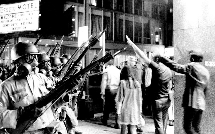 A group of protesters raise their arms in the air and taunt bayonet-armed National Guardsmen near Michigan Avenue in Chicago on Aug. 28, 1968. Police and National Guardsmen battled the demonstrators during the evening. Anti-war street violence contributed greatly to the election of Richard Nixon as president, says columnist M.D. Harmon.