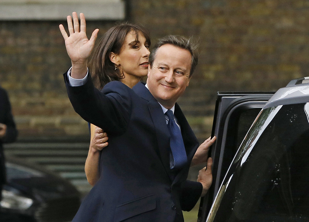 David Cameron, with his wife Samantha, waves to the media as leaves 10 Downing Street in London for the last time, Wednesday. Associated Press