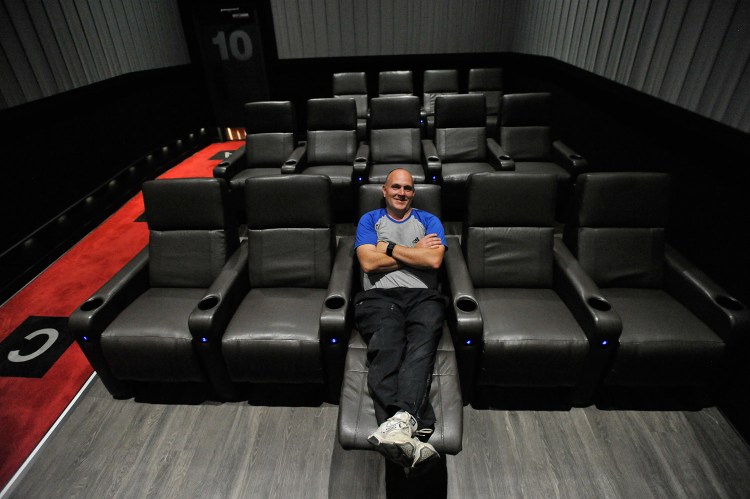 Andrew Poore, vice president of operations for the Flagship cinema chain, stretches out in a recliner in one of the 10 theaters at Flagship Premium Cinemas in Falmouth on Thursday.  